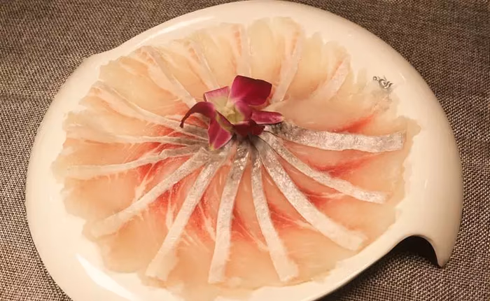 궁탄베이헤이궈훠궈의 흰 접시에 꽃 모양으로 펼친 얇은 생선 살