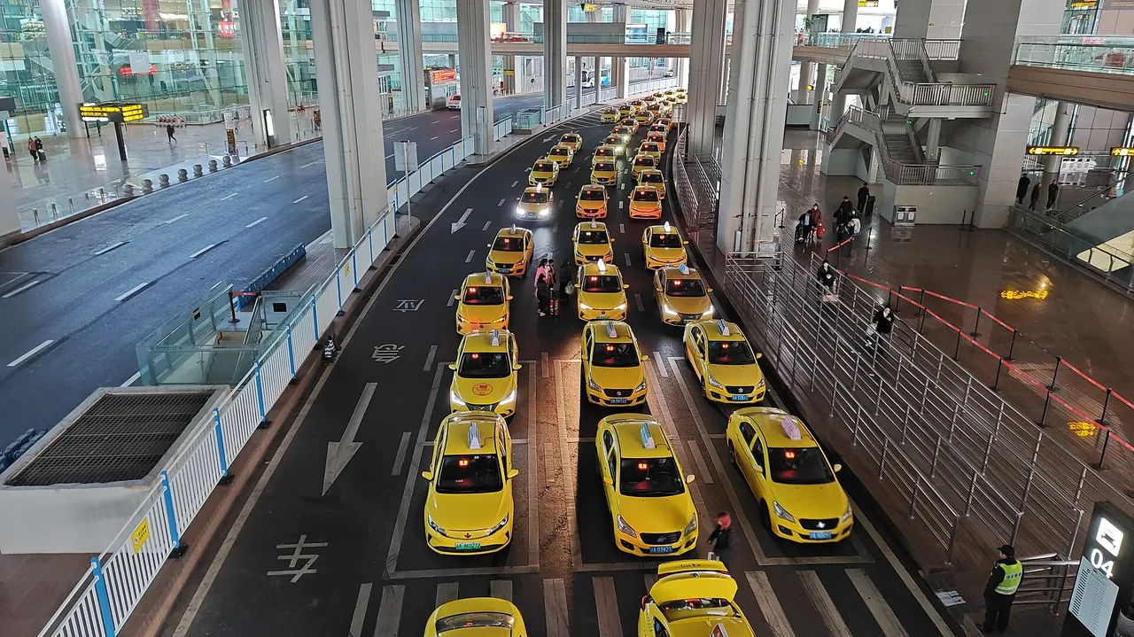 Yellow taxis, passenger queue barriers and bay 04 at Jiangbei Airport Terminal 3