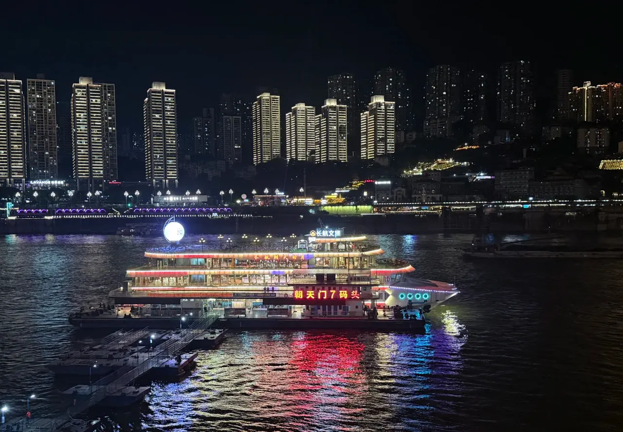 The illuminated 朝天皓月 cruise boat beside the Chaotianmen Pier 7 sign and boarding gangways