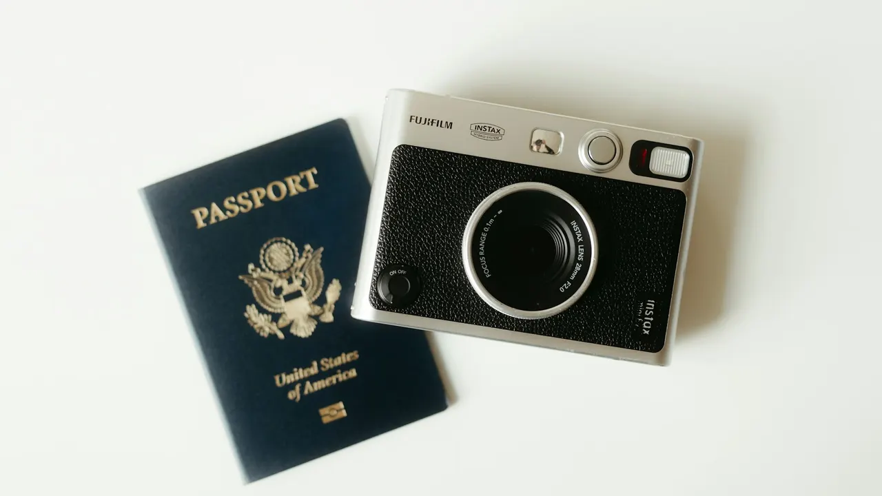 US passport and compact camera on a light surface