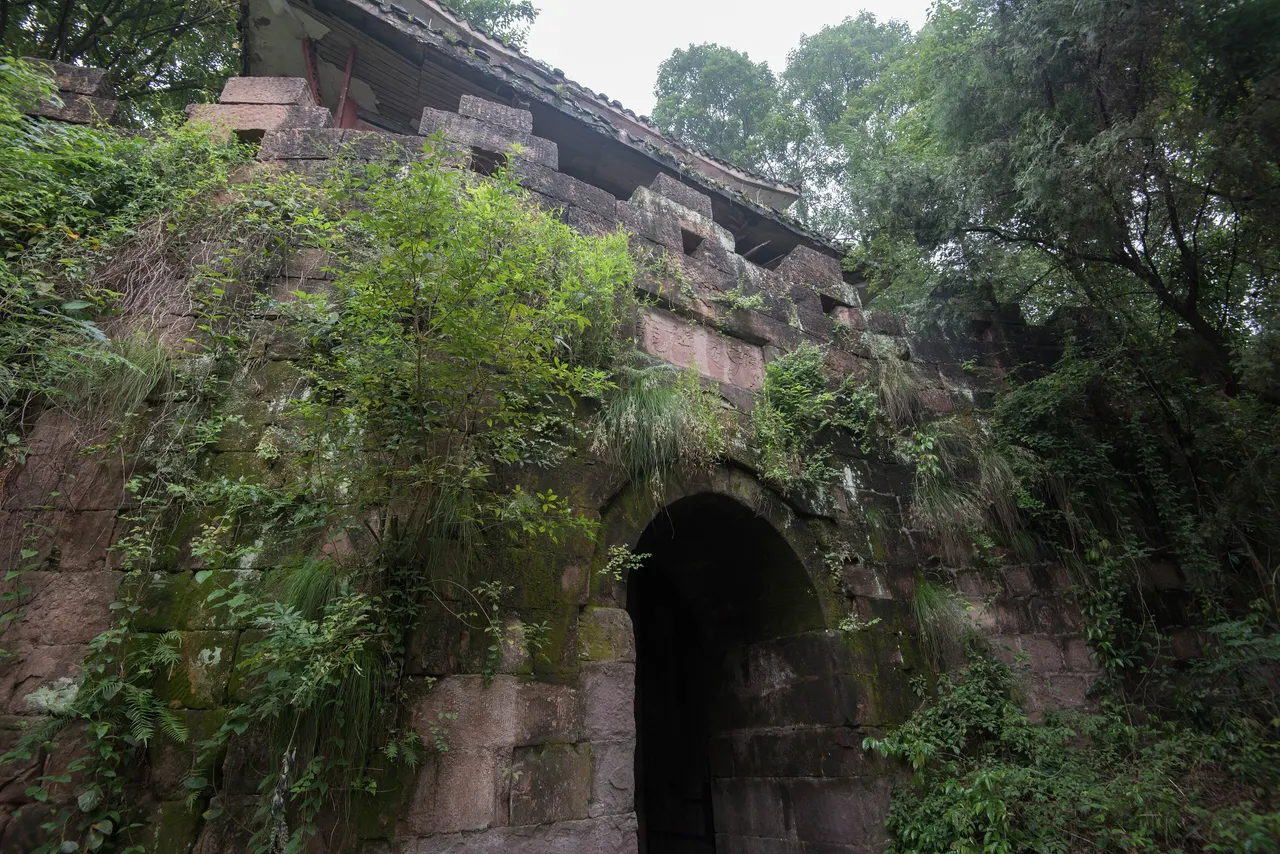 The stone arch of Huguo Gate, with its long fortress wall and surrounding trees