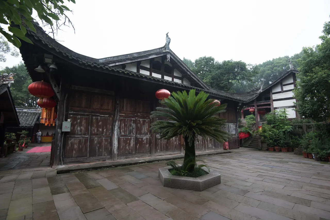 Timber halls around Huguo Temple’s stone courtyard, with red lanterns and potted plants