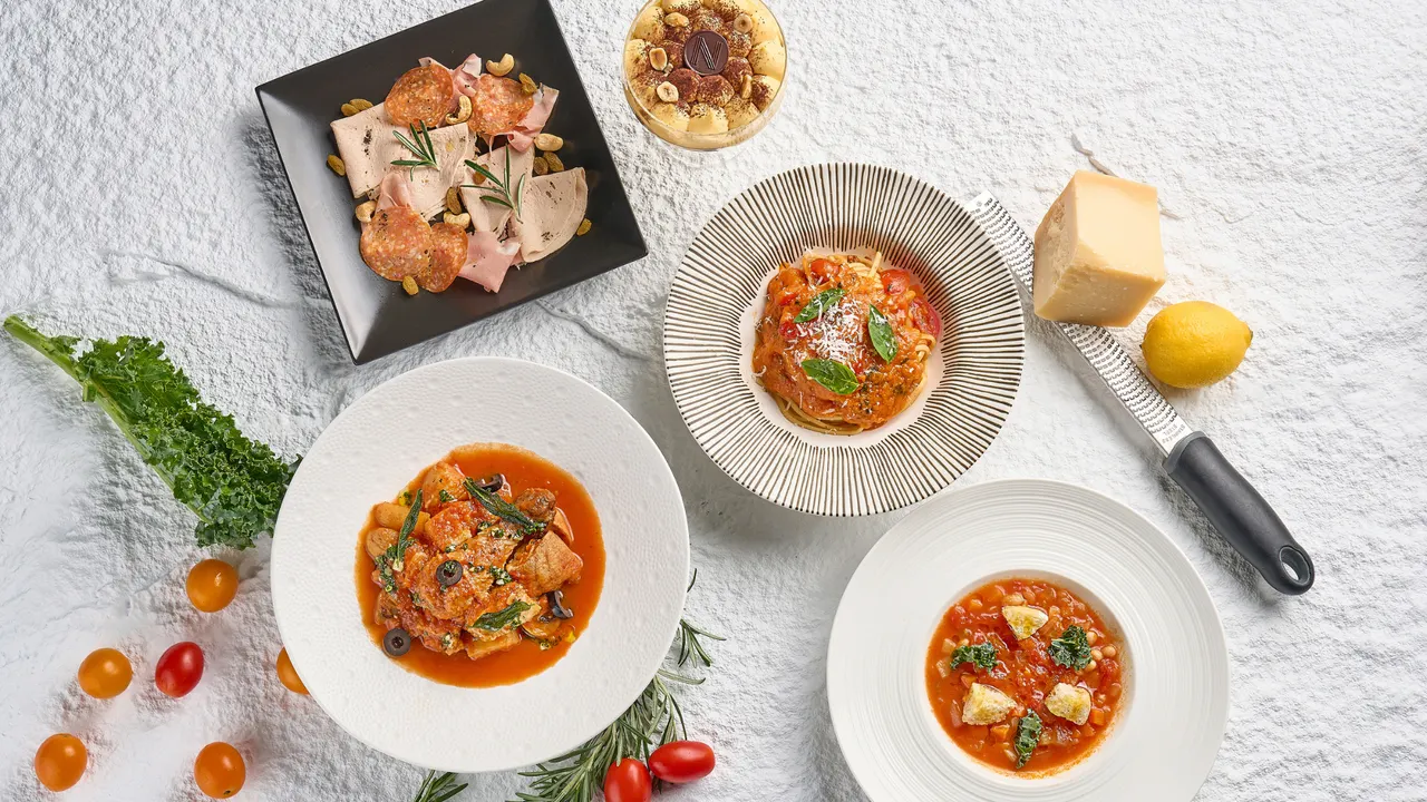 Pasta al pomodoro e altri piatti su una tavola alla Niccolo Kitchen.