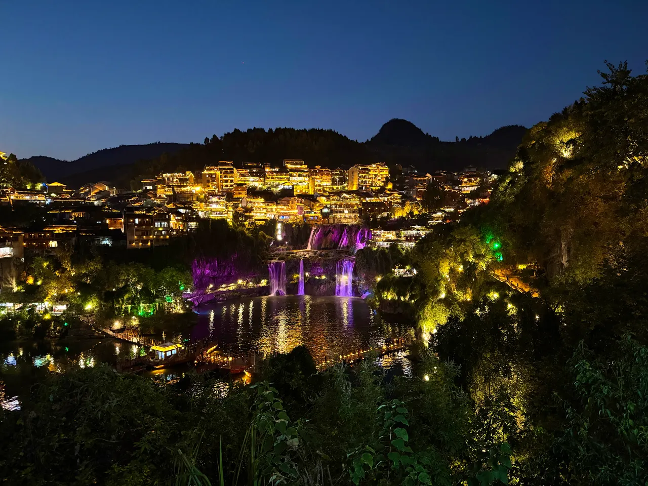 Furong Town’s waterfall and hillside houses lit up at dusk