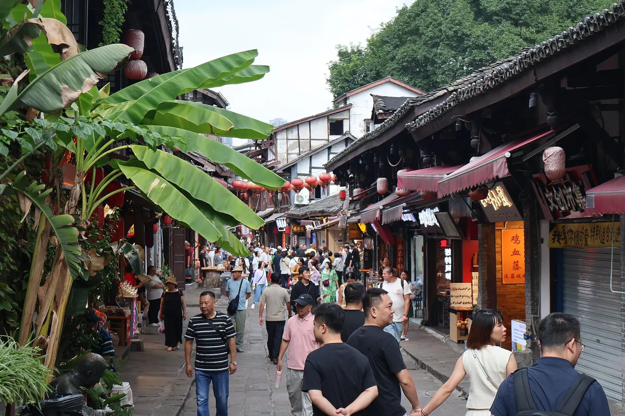 Pedestrians browsing food stalls along a stone-paved street in Ciqikou.