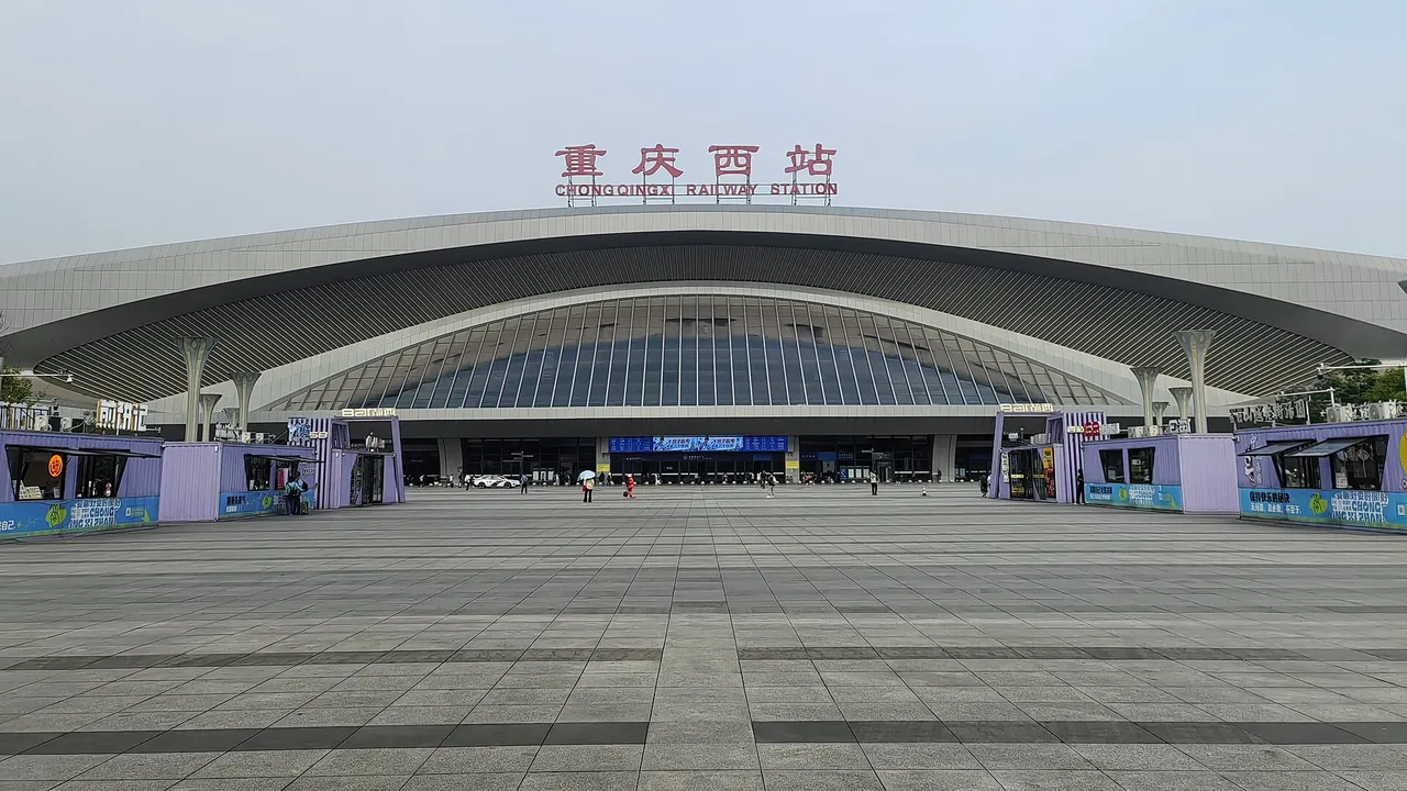 The curved facade of Chongqing West station above its entrance plaza.