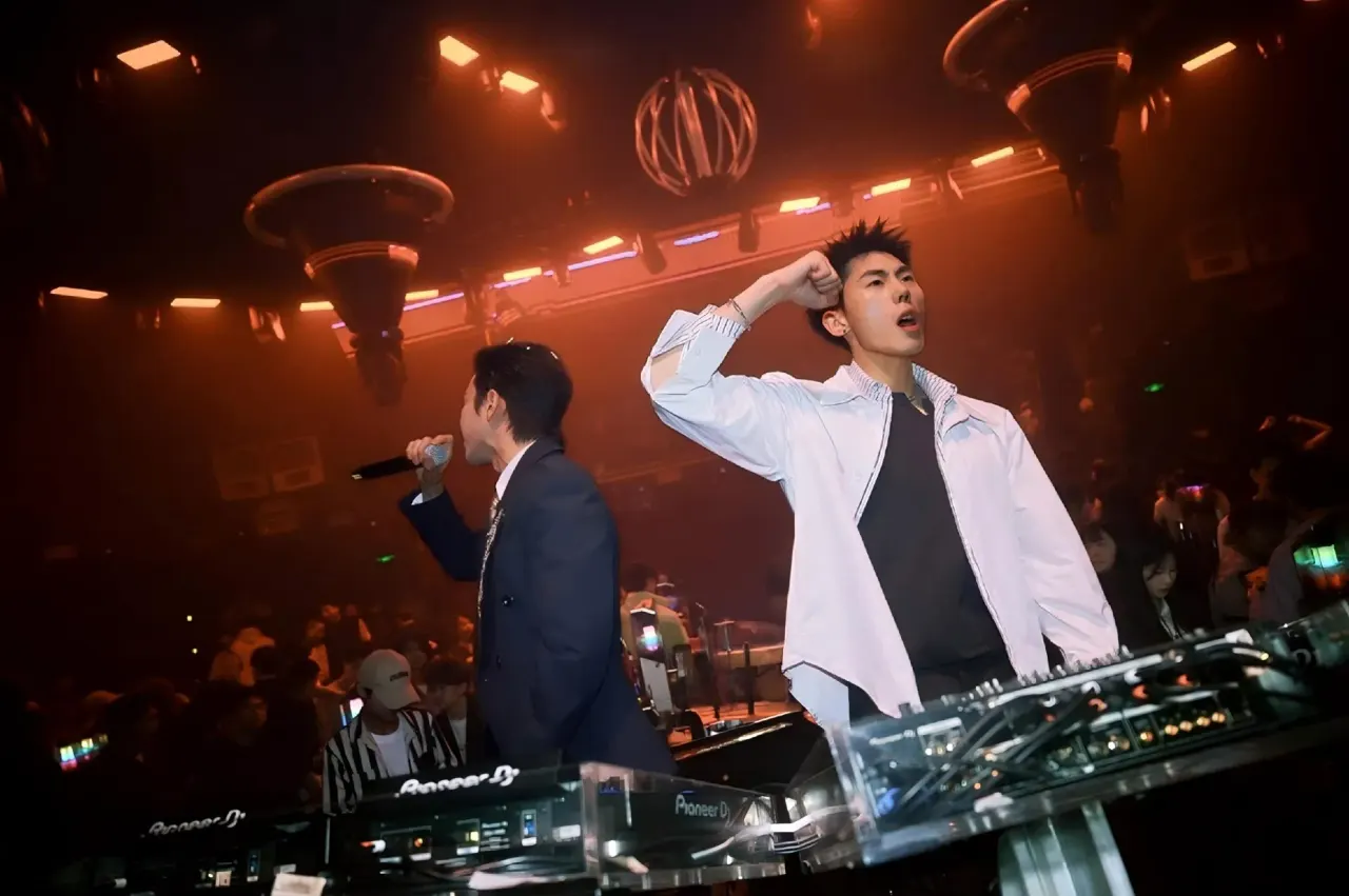 DJ and MC performing under orange lights at ESMI Jiangbei