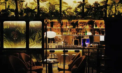 Bar counter, chairs and a plant-covered wall at Flavor Lounge in Deyi World