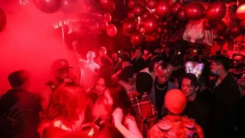 Party guests under red lights at Orangutan Bunker on 9th Street