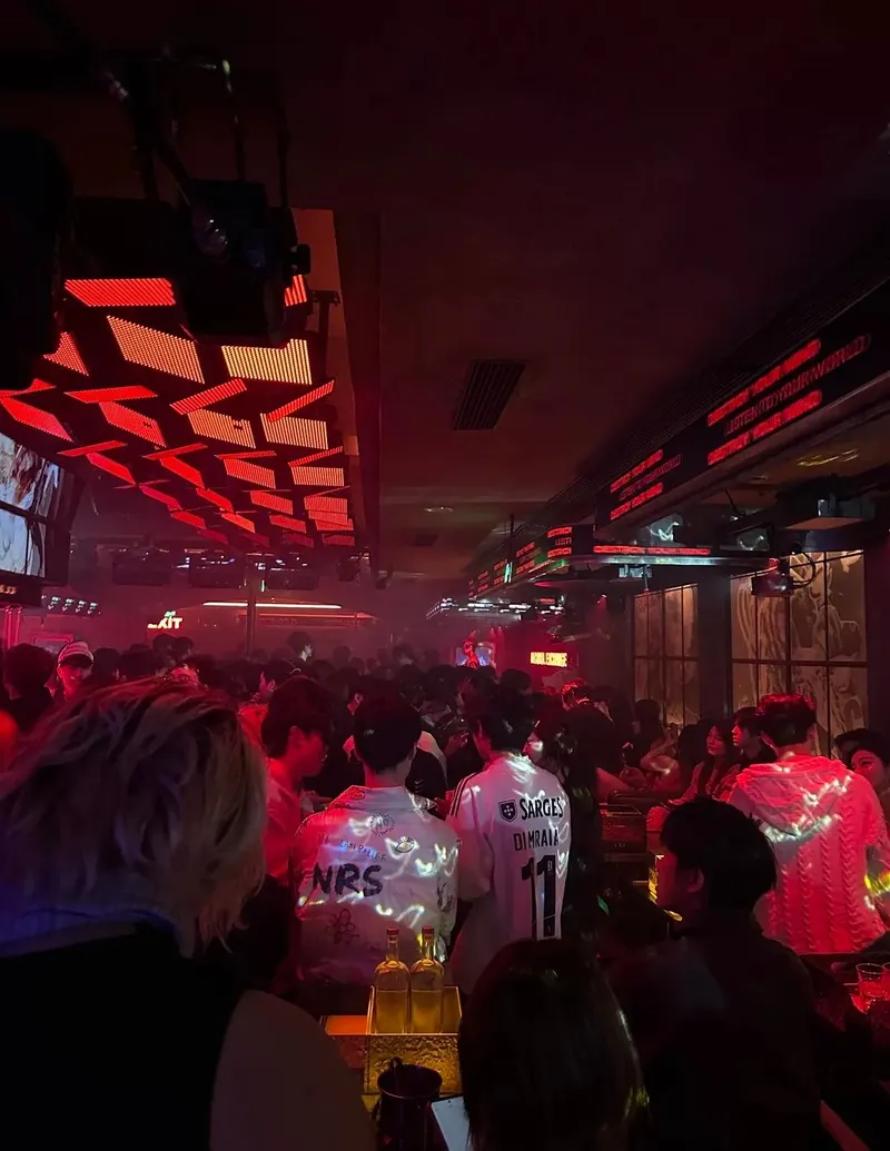 A crowded dance floor beneath red ceiling lights at TEETHGOLD on 9th Street