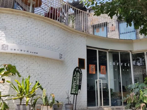 White brick façade, sign and glass entrance of Seldom café in Shancheng Lane.