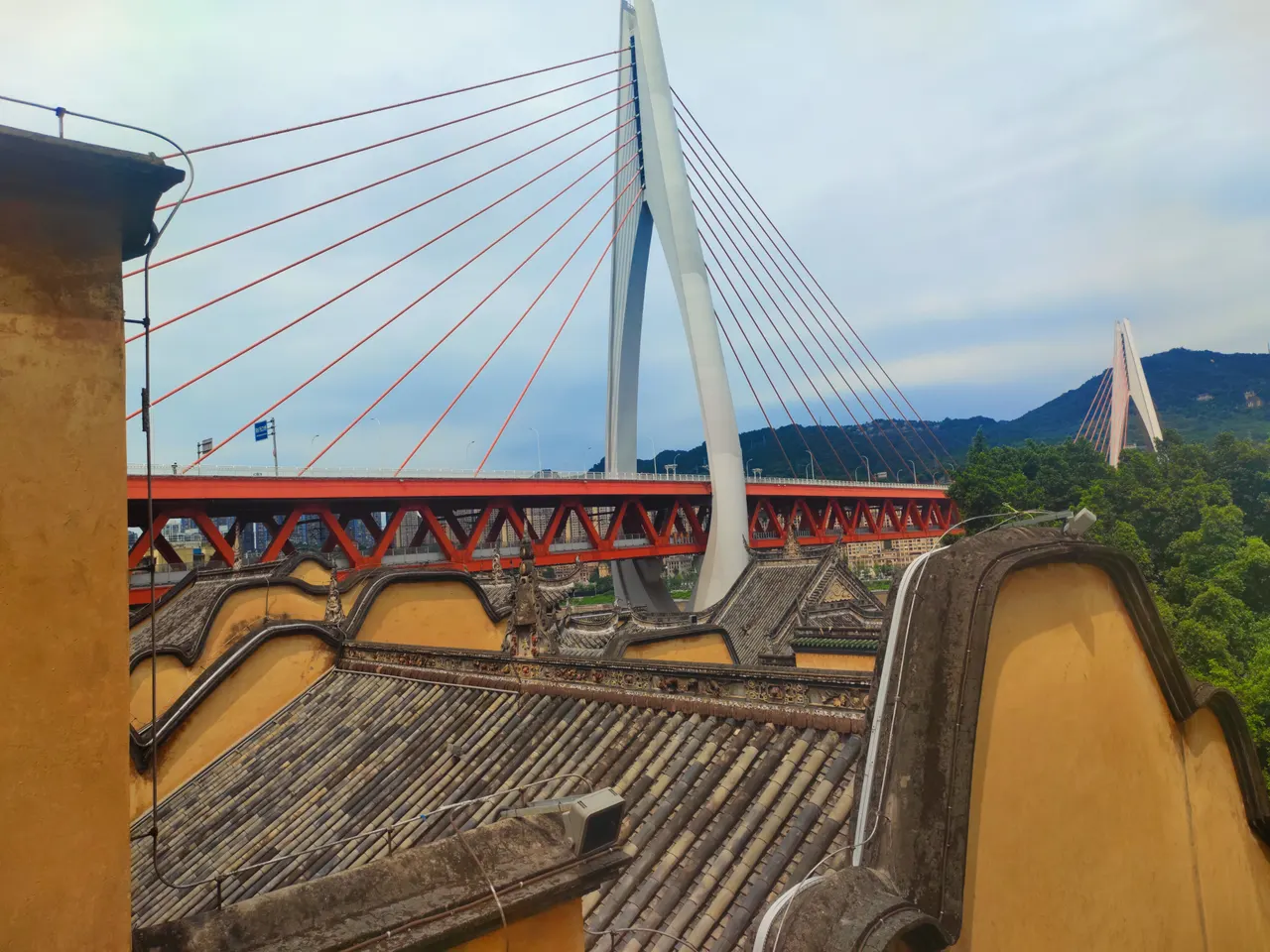 Yellow walls and tiled roofs of Huguang Guild Hall beneath Dongshuimen Bridge