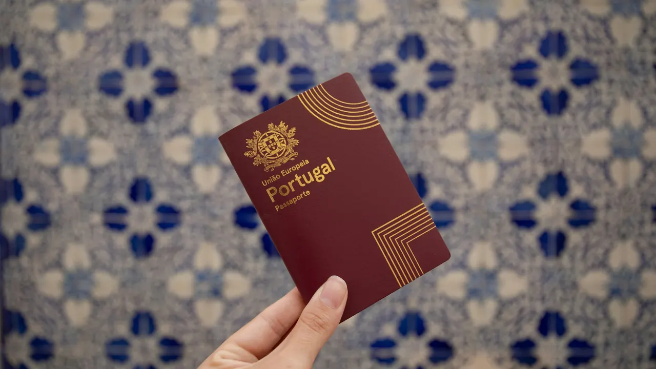 Passaporte português na mão, com azulejos azuis e brancos ao fundo