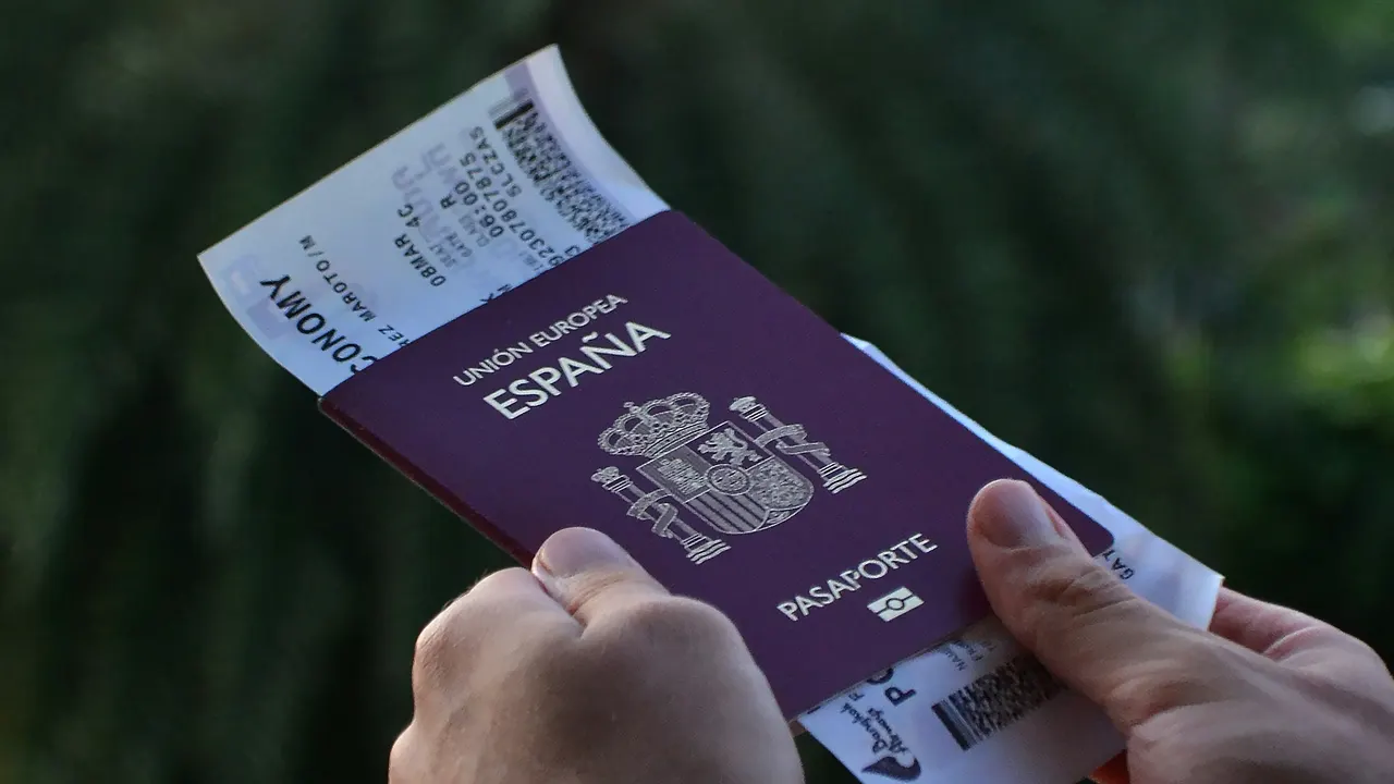 Pasaporte español y tarjeta de embarque en las manos de un viajero