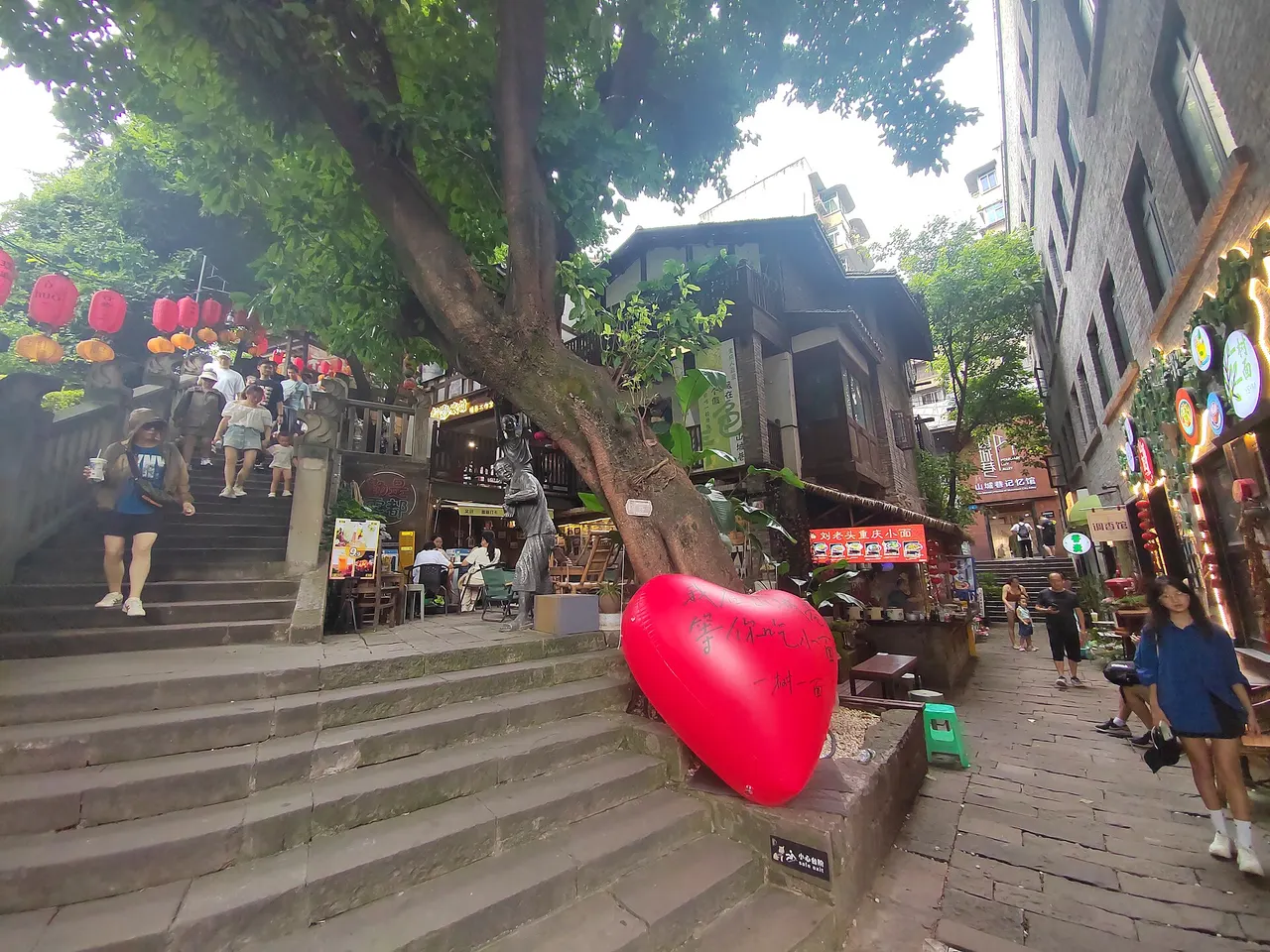 Stone stairs splitting around a tree between shops and old houses in Mountain City Lane