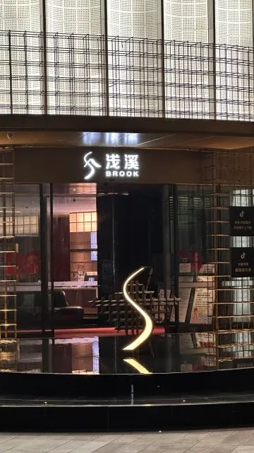 淺溪 BROOK 發光招牌、弧形金屬格柵與玻璃入口