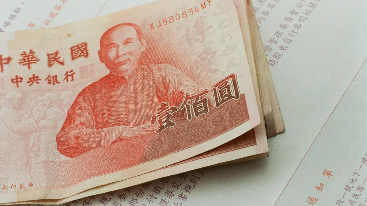 文件上放著多張新臺幣一百元紙鈔