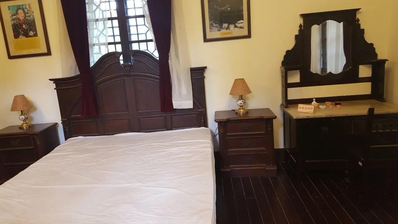 黃山松廳內的宋美齡臥室展示，木床旁有床頭櫃與梳妝台