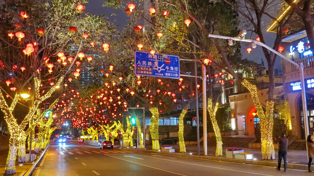 中山四路夜間街景，沿街樹木掛著紅燈籠，灰磚建築在道路旁