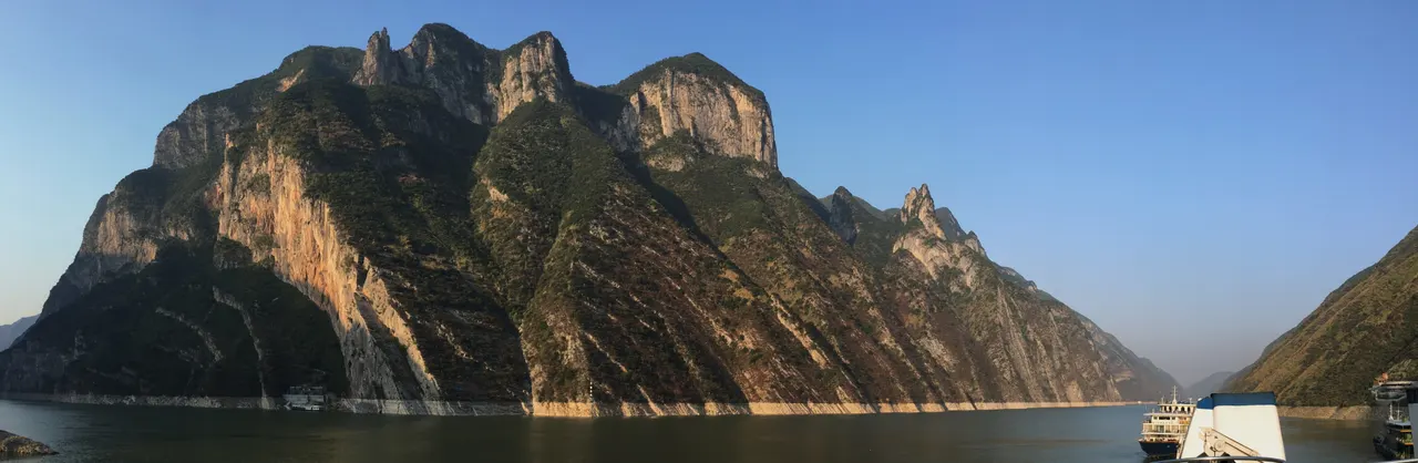 Golden sunlight falls on the steep cliffs above the Yangtze River in Wu Gorge.