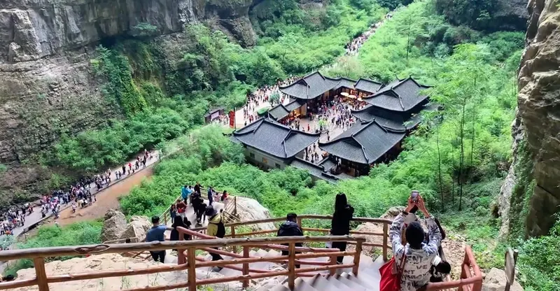 Visitors descending stone steps toward Tianfu post house at Wulong